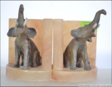 A pair of mid century marble and painted faux bronze elephant bookends in the manner of Nangreb.