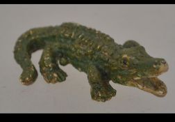 A cold painted bronze figurine of an alligator.