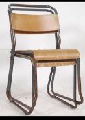 A pair of vintage 20th century tubular painted framed industrial stacking chairs having ply panel