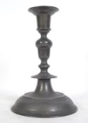 A pewter candlestick in the 17th century style being of large form raised on a terraced base with