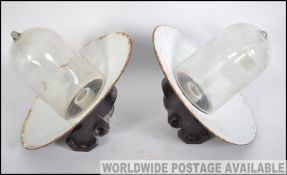 A pair of vintage mid century dairy lamps having glass bulbs set to black and white enamel painted