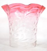 An early 20th century part cranberry and clear glass oil lamp shade with scalloped edgings