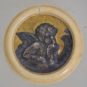 An ivory framed gilt and silver roundel of a pensive cherub - putti.