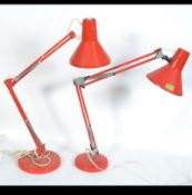A 20th century HCF Denmark red anglepoise desk lamp with circular base and two tone pendant shade.