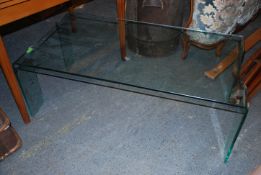 A contemporary late 20th century glass coffee table having pierced ends,