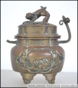 A late 19th / early 20th century twin handled Chinese Bronze lidded censor raised on four feet with