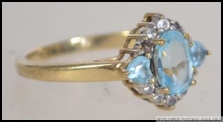 A hallmarked 9ct gold ring set with pear shaped blue topaz surrounded by white stones. size N / O.