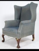A late 19th century wingback Chesterfield armchair being raised on claw and ball feet with a deep