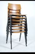 A set of retro mid century beech wood panel seat stacking chairs from a school / factory workroom.