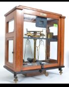 OERTLING Oak and glass cased brass scales with weights. Measures: 50cms high.