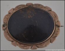 A 9ct gold and bloodstone agate brooch with chased edgings and pin verso. Weight 9.