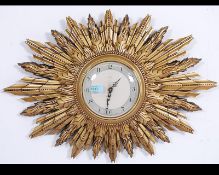 A mid century Smiths of Enfield Enfield sunburst clock with central convex glass having roman