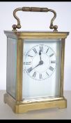 An early 20th century brass carriage clock complete with the key having enamel face with faceted