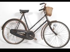 A vintage early 20th century Rod Brake bicycle complete with the basket to the front and leather