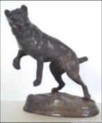 A bronze early 20th century cast figurine of a fighting mastiff dog being raised on a naturalistic