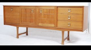 A 1970's retro Danish influenced teak wood sideboard raised on tapered legs with cupboards and