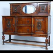 An early 20th century Edwardian oak mirror back sideboard with ornate carvings with a run of