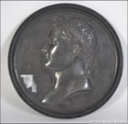 A 19th century cast metal plaque medal believed to be of Napoleon being signed for F. Andrieu.