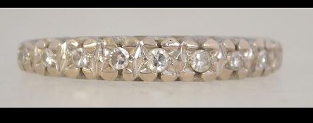A white metal and 9 stone diamond half eternity ring. Size P. Weight 3.6g.
