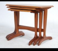 A retro 20th century teak wood nest of three graduating tables raised on shaped supports having