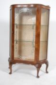 A 1950's walnut glass chinas display cabinet being raised on cabriole legs with mirror glass lined