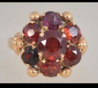 A Victorian 18ct gold cluster ring set with orange and purple stones possibly Garnet.