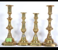 A pair of 19th century brass candle sticks with pushers along with another pair of early 20th