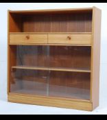 A mid 20th century teak wood display cabinet / bookcase by Nathan having a pair of glazed sliding