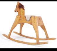A mid century solid pine wooden rocking horse raised on shaped runners having saddle and mane.