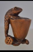 A carved fruit wood Japanese netsuke depicting a frog on a lotus leaf - flower bearing signature to