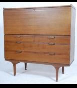 A 1970's large Danish influence teak wood bureau - desk raised on turned legs having fall front