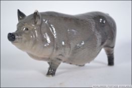 A Royal Doulton figure of a Vietnamese pot bellied pig in tonal grey finish bearing stamp to the