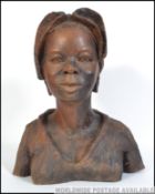 A large carved wooden bust of an African tribal lady being carved from a single piece of wood,