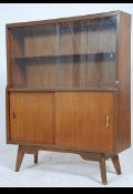 A mid century Danish influenced teak display cabinet having glazed cabinet being raised on tapered