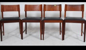 A set of four retro teak wood Danish inspired dining chairs raised on tapering legs united by