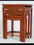 A 20th century Chinese hardwood trio nest of tables with geometric carved friezes on squared legs