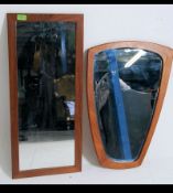 A 1970's Danish teak wood wall mirror of shaped form being stamped Made in Denmark to verso