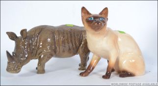 A SylvaC ceramic figurine of a rhino together with another SylvaC figurine of a Siamese cat.