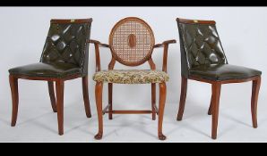 A pair of 20th century Chesterfield style club dining chairs with a green leather button back
