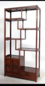 A Chinese rosewood room divider bookcase having sectional shelves raised on shaped legs with
