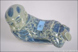A Chinese blue and white ceramic pillow in the form of a recumbant buddha ( see illustrations ).