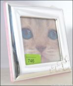 A contemporary silver 925 photograph frame having family of ducks to the corner.