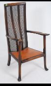 An early 20th century Arts & Crafts beechwood high back bergere high back chair with scalloped