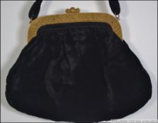 A black velvet ladies evening bag with gilt metal frame and clasp decorated with gold overlay in
