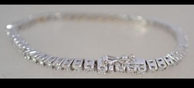 A hallmarked 18ct white gold and diamond tennis bracelet set with a total of 3cts diamonds.