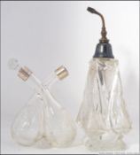 A silver and cut glass twin perfume bottle being intertwined together with a silver and cut glass
