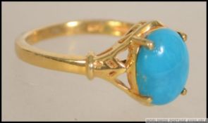 A gilt ( 925 stamped ) silver ring having a Cabochon prong set Sleeping Beauty turquoise stone.