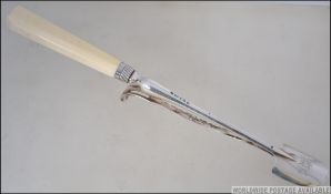 A silver hallmarked Ivory handled stilton scoop with pusher.