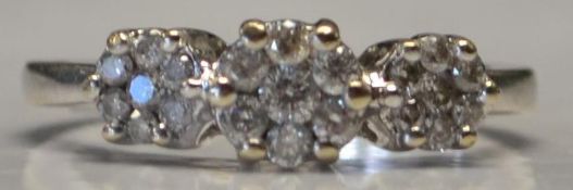 A hallmarked 18ct white gold triple cluster ring set with 50pts diamonds. Hallmarked for London.