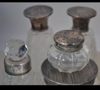 A collection of cut glass dressing table items with silver hallmarked tops together with other